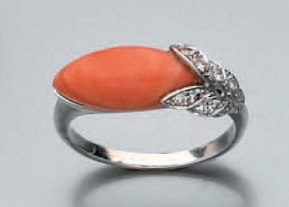 BAGUE en platine et or gris 14 carats (585 millièmes) serti de corail taillé en navette épaulé d'un motif feuillagé serti de diamants 8/