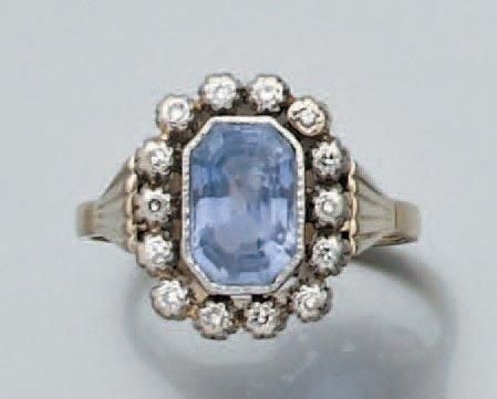 BAGUE en platine et or gris serti d'un saphir taillé à degrés, entouré de petits diamants 8/