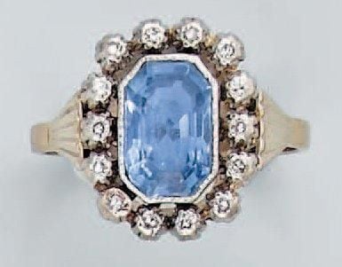 BAGUE en platine et or gris serti d'un saphir taillé à degrés entouré de petits diamants 8/
