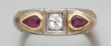 BAGUE en platine et or jaune finement ciselés sertis d'un diamant taille ancienne épaulé de deux rubis de forme poir