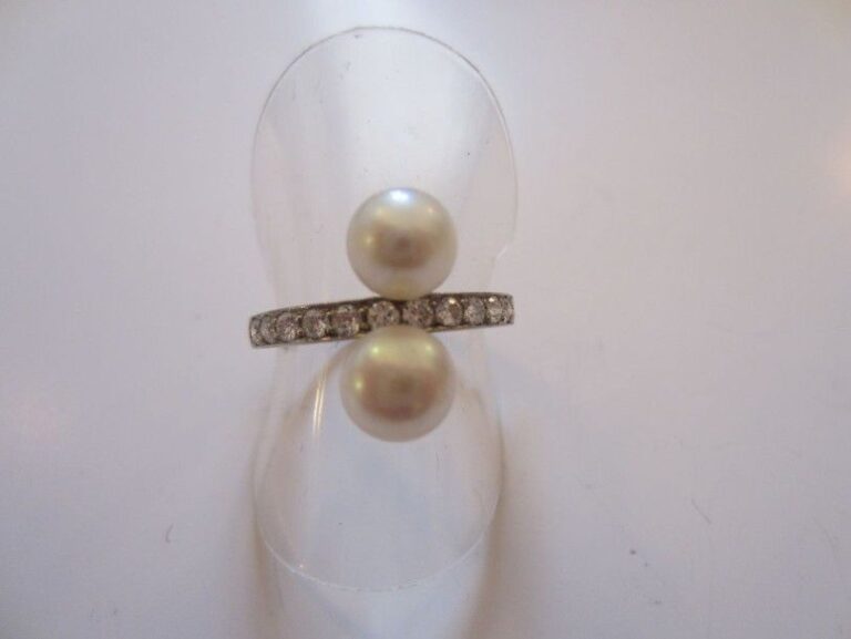 BAGUE en platine serti d'un alignement de diamants taille brillant épaulé de deux perles probablement fines et légèrement bouto