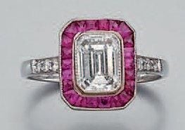 BAGUE en platine serti d'un diamant entouré de rubis calibrés et facettés, et épaulé de diamant