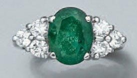 BAGUE en platine serti d'une émeraude de forme ovale épaulée de six diamants taille brillan