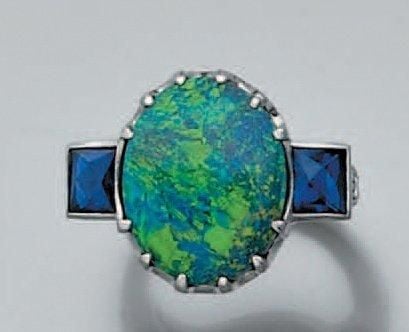 BAGUE en platine serti d'une opale noire de forme ovale épaulée de saphirs calibrés et soulignée de diamants taille brillan