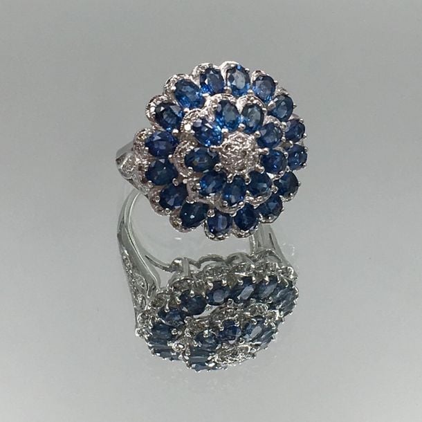 BAGUE «fleur circulaire» en or gris (750 millièmes) serti de saphirs ovales, entouré et diamants taille brillan
