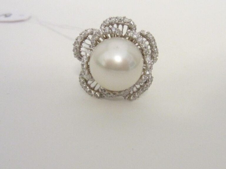 BAGUE «fleur» en or gris (750 millièmes) ajouré serti d'une perle de culture blanche des Mers du Sud, entourée de lignes de diamants, à motifs de pétale