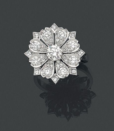 BAGUE « fleur » en or gris (750 millièmes) finement ajouré serti de diamants taille brillant dont un, au centre, plus important et diamants taille émeraud