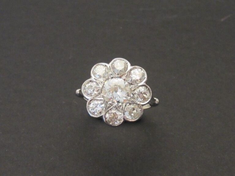 BAGUE «fleur» en or gris (750 millièmes) serti de neuf diamants taille ancienne et taille brillant dont au centre, un plus importan