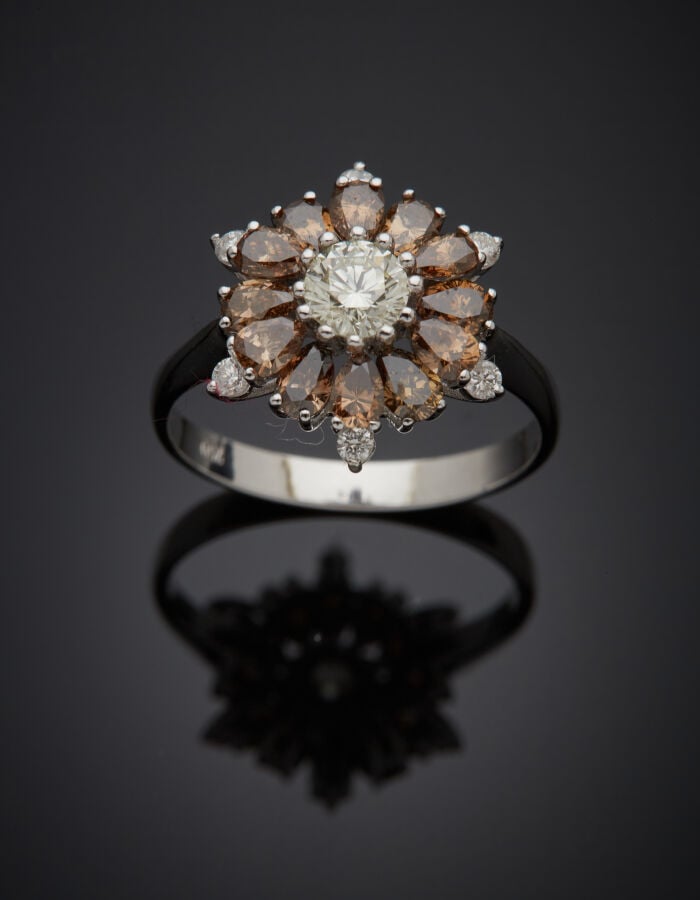 BAGUE "fleur" en or gris (750‰) serti d'un diamant blanc taille brillant, entou…