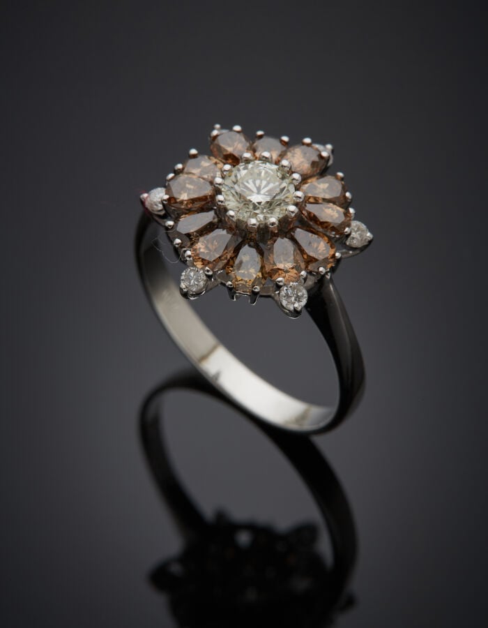BAGUE "fleur" en or gris (750‰) serti d'un diamant blanc taille brillant, entou…