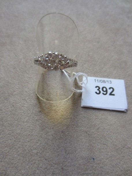BAGUE «fleur» en or gris ajouré serti de diamants taille brillant dont sept, au centre, plus important