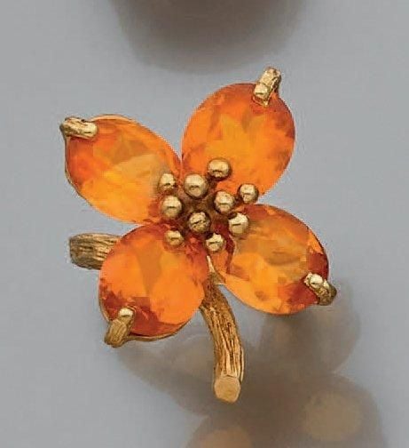 BAGUE «fleur» en or jaune (750 millièmes) finement ciselé et boulé serti de quatre pierres de couleur orang