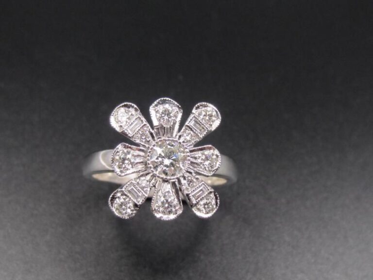 BAGUE «fleur stylisée» en or gris (750 millièmes) ajouré serti de diamants taille brillant dont un, au centre, plus important, et diamants baguette