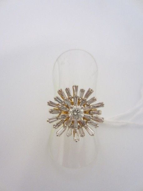 BAGUE «fleur stylisée» en or jaune et or gris (750 millièmes) serti d?un diamant taille brillant entouré de diamants taepers, à motif rayonnan