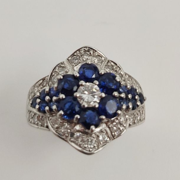 •BAGUE «fleurette» en or gris (750‰) serti de saphirs ronds, soulignés de diamants taille brillan