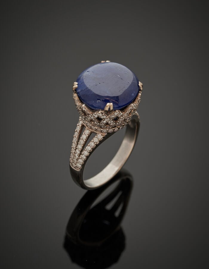 BAGUE haute en or gris (750‰) ajouré serti d'un saphir cabochon légèrement étoi…
