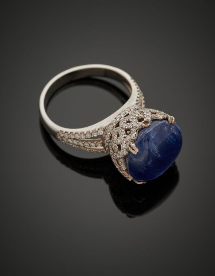 BAGUE haute en or gris (750‰) ajouré serti d'un saphir cabochon légèrement étoi…