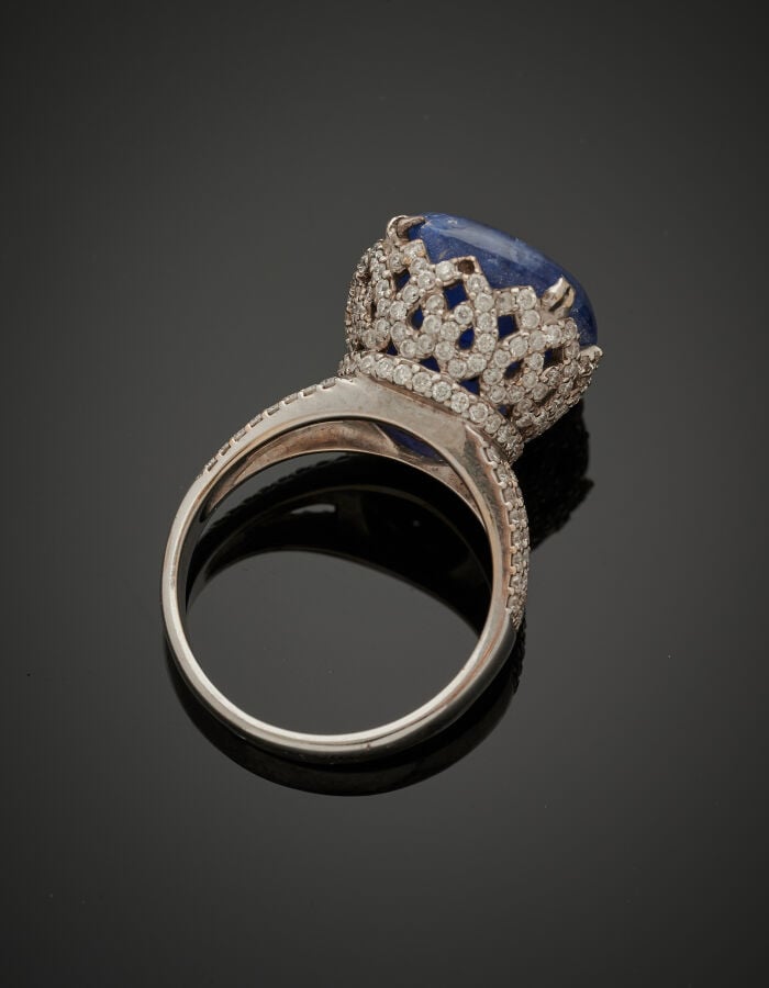 BAGUE haute en or gris (750‰) ajouré serti d'un saphir cabochon légèrement étoi…