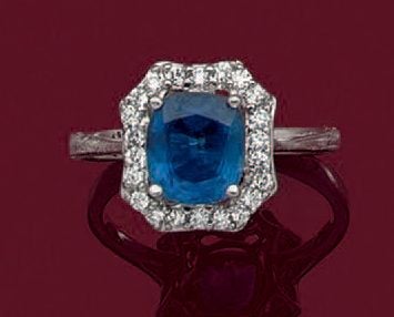 BAGUE hexagonale en or gris (750 millièmes) serti d'un saphir de forme coussin, pesant 2,27 carats, entouré de petits diamants taille brillan