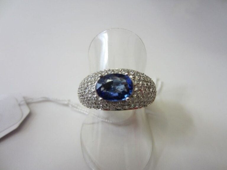 BAGUE jonc en or gris serti d'un saphir de forme ovale entouré d'un pavage bombé de diamants taille brillan