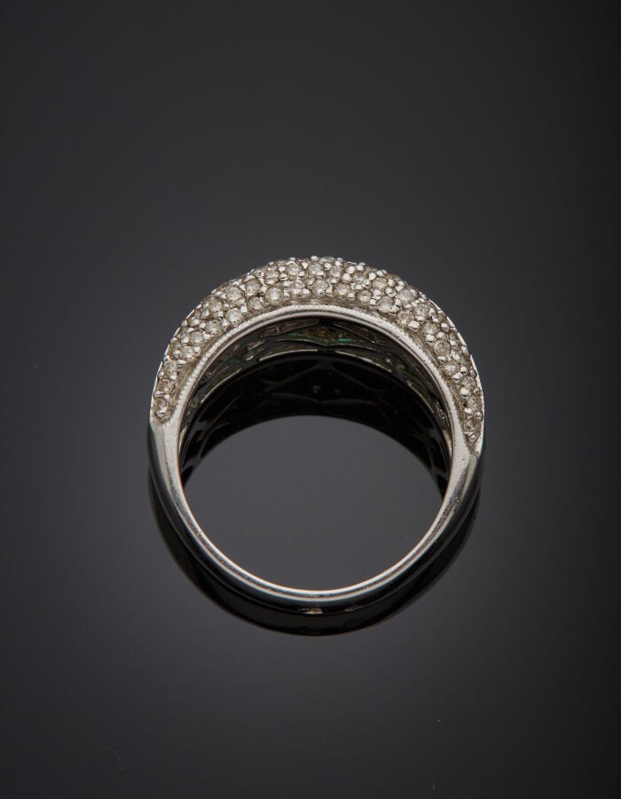 BAGUE "jonc" en or gris(750‰) serti d'un alignement d'émeraudes calibrées épaul…