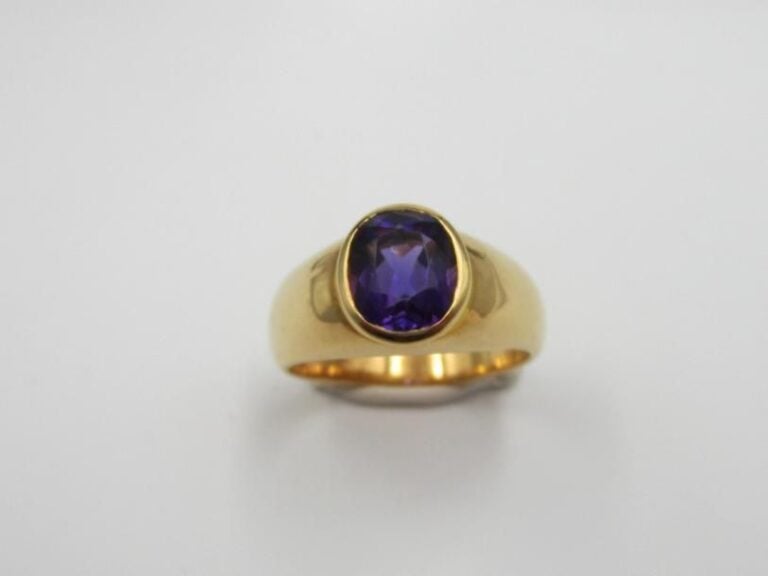 BAGUE jonc en or jaune (750 millièmes) orné d'une améthyste de forme ovale en serti clo