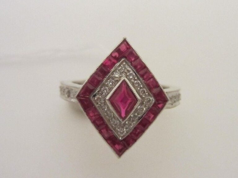 BAGUE losangique en or gris (750 millièmes) serti de diamants taille brillant et rubis calibré