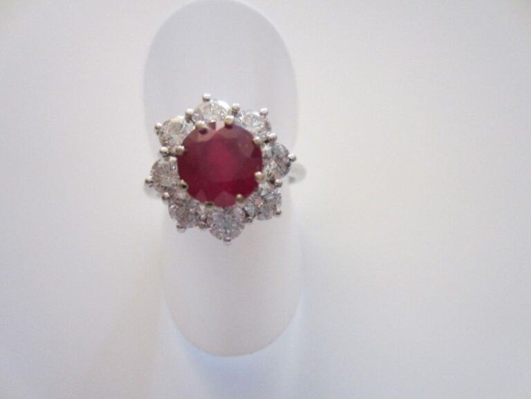 BAGUE «marguerite» en or gris 14 carats (585 millièmes) serti d'un rubis rond entouré de diamants taille brillan