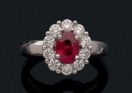 BAGUE «marguerite» en or gris (750 millièmes) serti d'un rubis ovale entouré de diamant