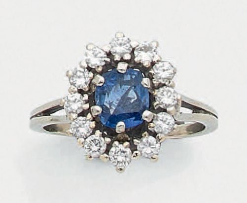 BAGUE «marguerite» en or gris (750 millièmes) serti d'un saphir de forme coussin entouré de diamants taille brillan