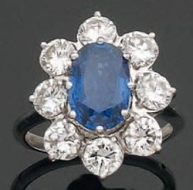 BAGUE « marguerite » en or gris serti d'un saphir de forme ovale entouré de diamants taille brillan