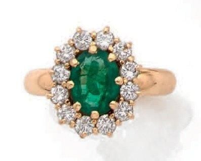BAGUE «marguerite » en or jaune (750 millièmes) serti d'une émeraude de forme ovale entourée de diamants taille brillan