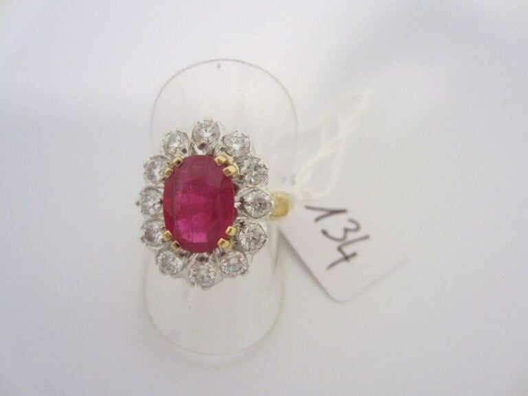 BAGUE marguerite en or jaune et or gris (750 millièmes) serti d?un rubis de forme ovale entouré de diamants taille brillan