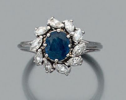 BAGUE «marguerite» en platine (850 millièmes) et or gris (750 millièmes) serti d'un saphir de forme coussin entouré de diamants taille navett