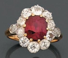 BAGUE «marguerite» en platine et or jaune serti d'un rubis de forme coussin entouré de diamants taille ancienn
