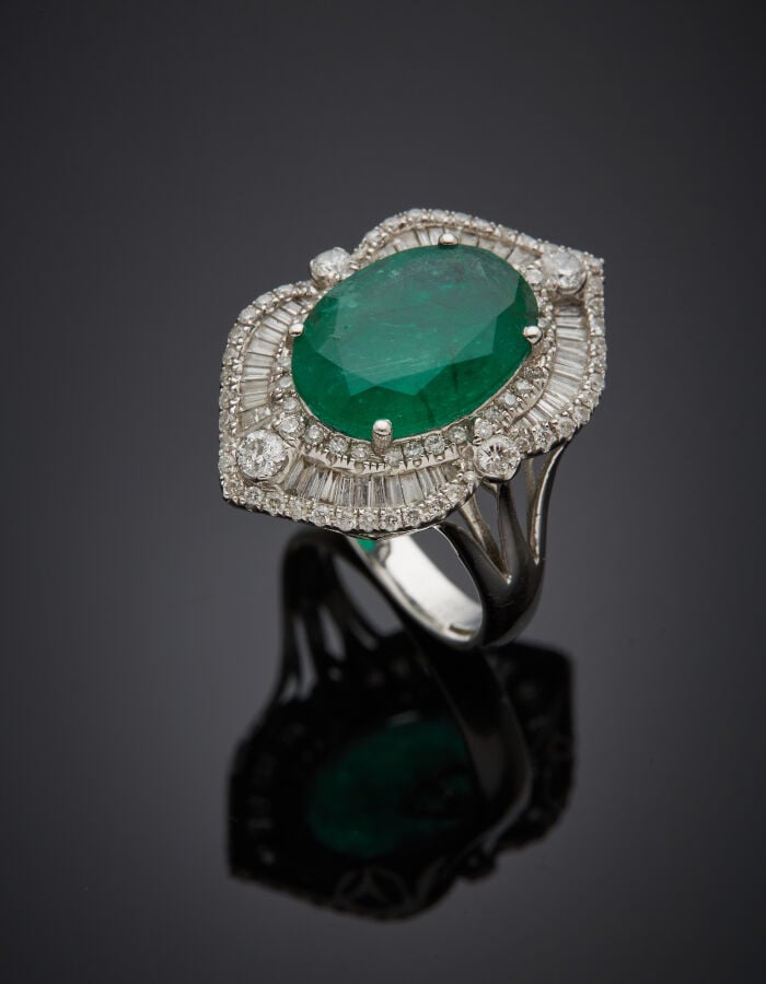 BAGUE "marquise" en or gris (750‰) sert d'une émeraude de forme ovale entourée…