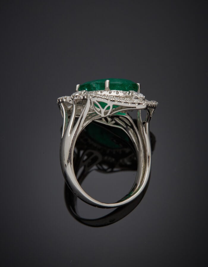 BAGUE "marquise" en or gris (750‰) sert d'une émeraude de forme ovale entourée…