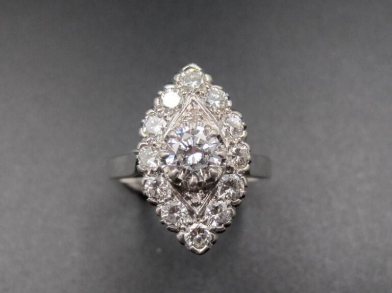 BAGUE « marquise » en platine (900 millièmes) et or gris (750 millièmes) serti de diamants taille brillant dont un au centre, plus important              Doigt : 51        Poids brut : 4,7 g
