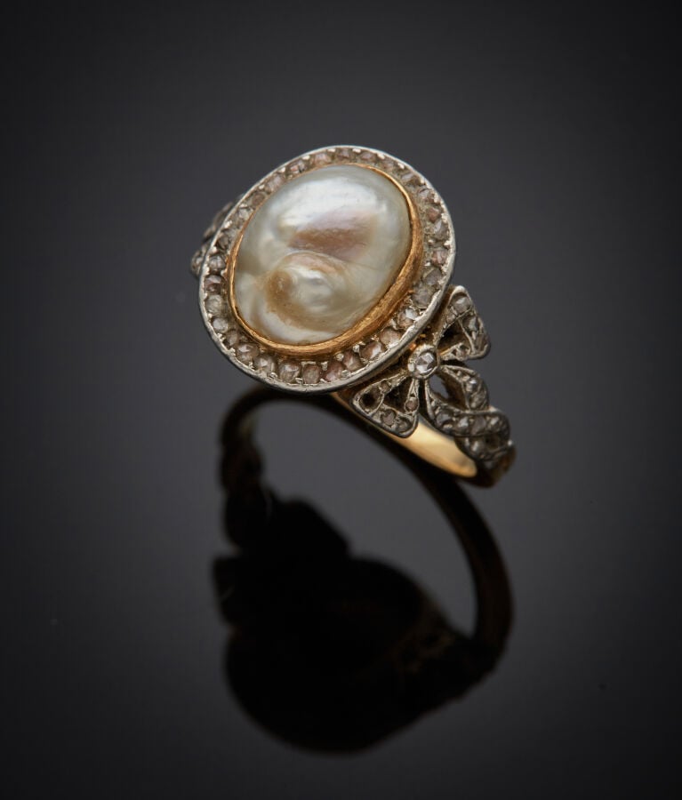 BAGUE "noeuds" en or jaune et or gris (750‰) ajouré ornée d'une soufflure de pe…