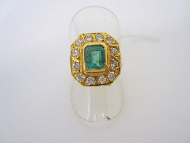 BAGUE octogonale en or jaune (750 millièmes), ornée d'une émeraude taillé à degrés entourée de diamants taille brillan
