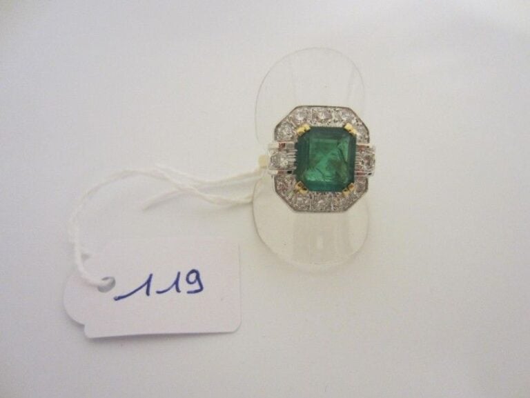 BAGUE octogonale en or jaune et or gris (750 millièmes) serti d'une émeraude rectangulaire taillée à degrés, entourée de diamants taille brillan
