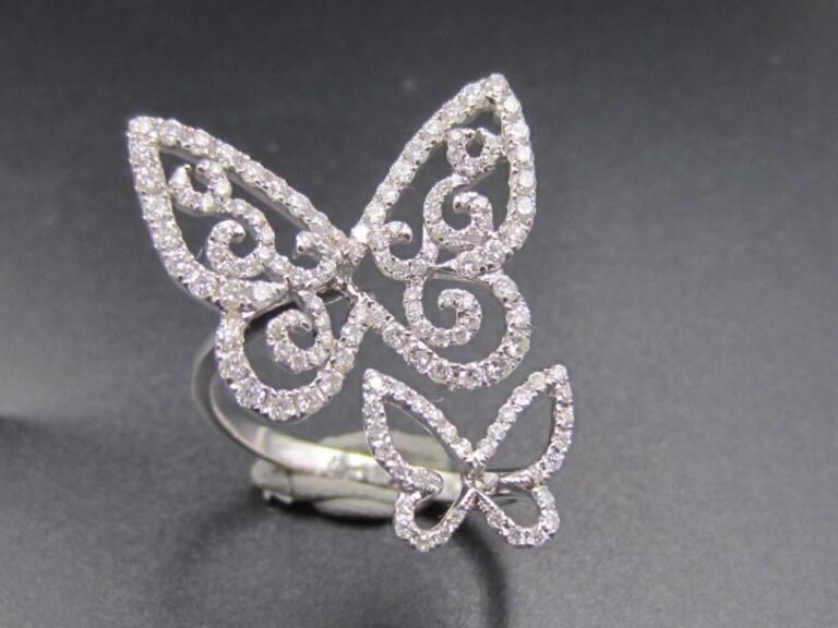 BAGUE ouverte en or gris (750 millièmes) ajouré à motifs de papillons et volutes, partiellement pavé de diamants taille brillan