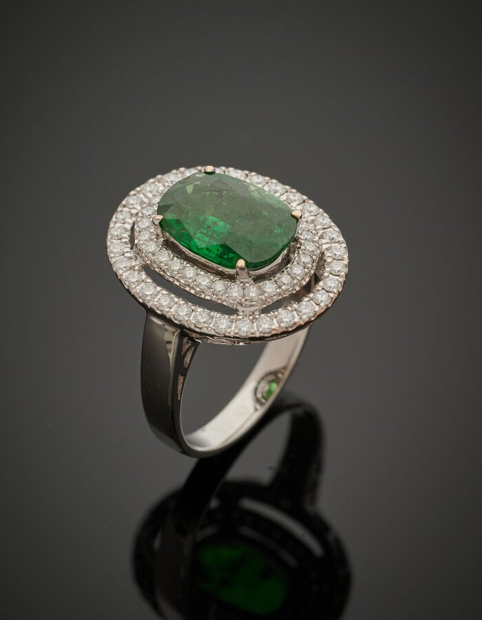 BAGUE ovale en or gris (750‰) ajouré, serti d'un grenat tsavorite pesant 2,69 c…