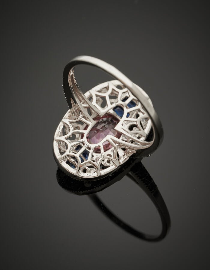 BAGUE ovale en or gris (750‰) finement ajouré de volutes, serti d'un zircon vio…