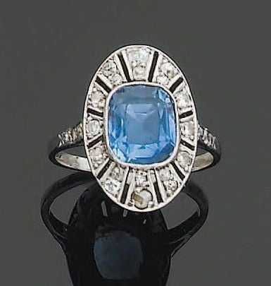 BAGUE ovale en platine ajouré serti d'un saphir de forme coussin entouré de diamants, à motif rayonnan