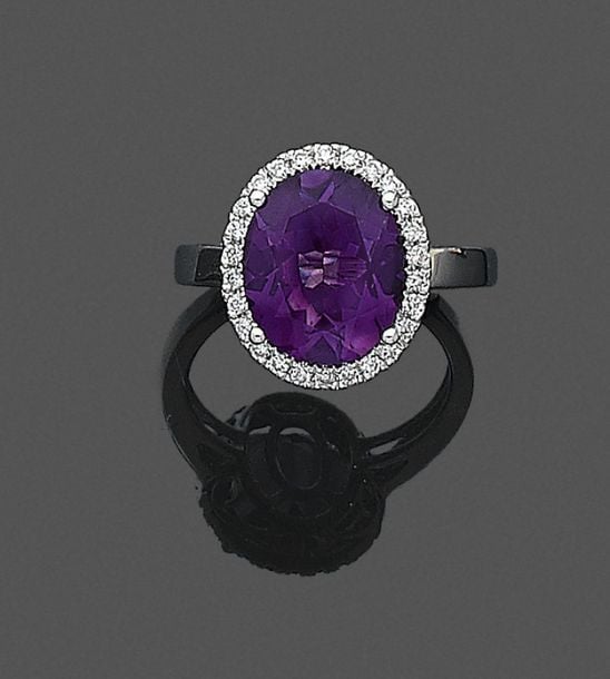 •BAGUE ovale or gris (750‰) serti d'une améthyste entourée de diamants taille brillan