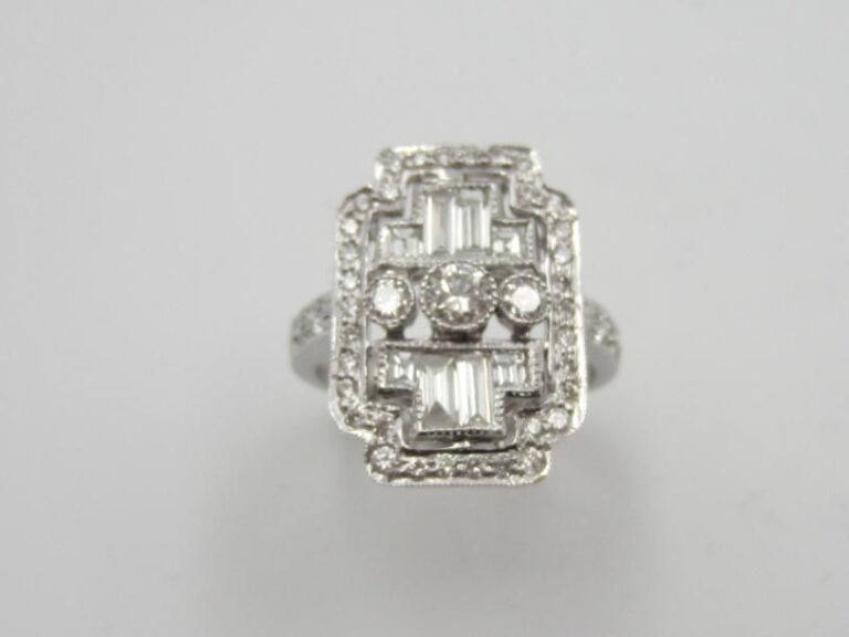BAGUE « plaque » en or gris (750 millièmes) finement ajouré serti de diamants taille brillant, baguettes et à degré