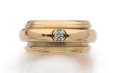 BAGUE «Possession» en or jaune (750 millièmes) partiellement godronné orné d'un anneau pivotant serti d'un diamant taille brillan