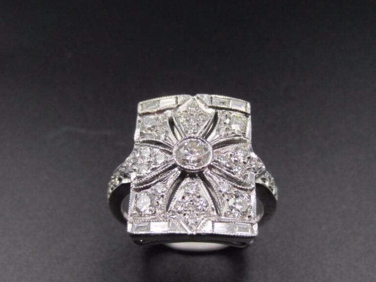 BAGUE rectangulaire en or gris (750 millièmes) finement ajouré à motif de « fleur » serti de diamants taille brillant et baguette