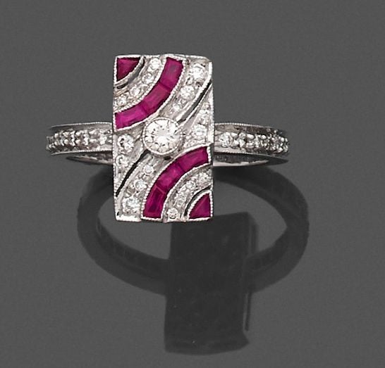 BAGUE rectangulaire en or gris (750 millièmes) pavé de diamants taille brillant, dont un au centre plus important, serti de rubis calibré